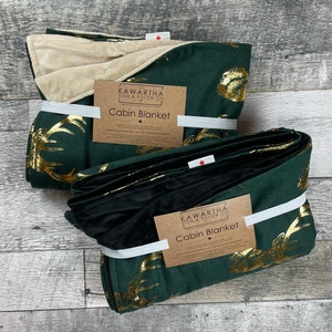 Photo with 2 throw blankets from The Kawartha Sign & Pillow Co, Hunter green throw with a gold foil stag print, backing options in black and tan chenille