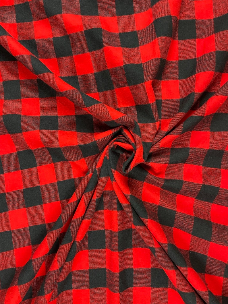 May include: Red and black buffalo plaid fabric. The fabric is woven with a checkered pattern and has a soft, textured feel.