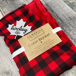 Buffalo Check blanket with red lining, hockey life embroidery throw blanket in red, and black. Canadiana, soft blanket lining cottage decor, home decor, side view of blanket