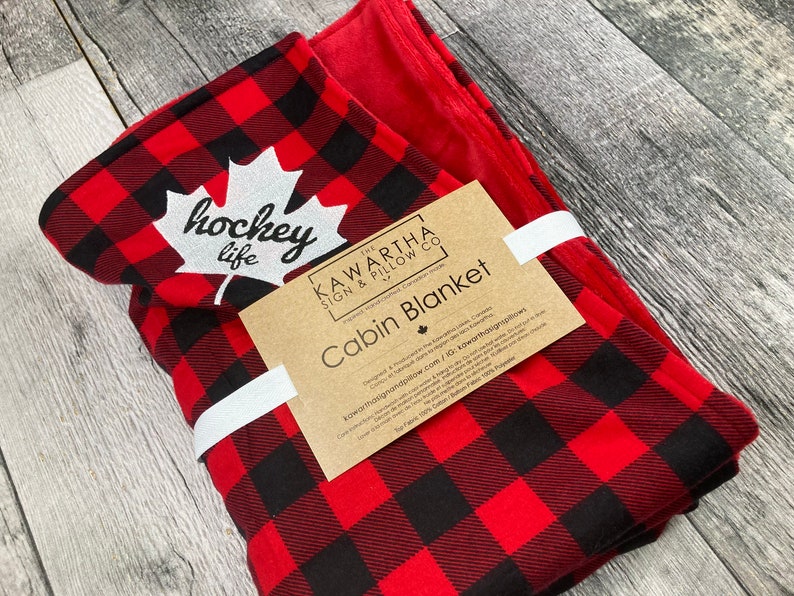 Buffalo Check blanket with red lining, hockey life embroidery throw blanket in red, and black. Canadiana, soft blanket lining cottage decor, home decor, side view of blanket