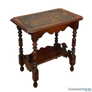 May include: A dark wood side table with a rectangular top and turned legs. The tabletop features a patterned design. The table has a lower shelf and a scalloped apron. The table is approximately 28 inches long, 16 inches wide, and 24 inches tall.