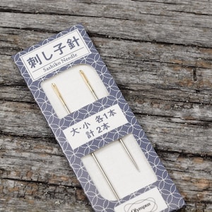 May include: A package of two sashiko needles, one large and one small. The package is blue with white text that reads "Sashiko Needle" and "大・小 各1本 計2本".