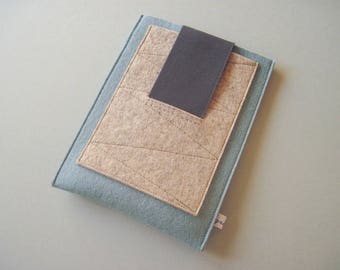 May include: A light blue felt case with a beige felt flap and a black elastic closure. The case has a geometric pattern.