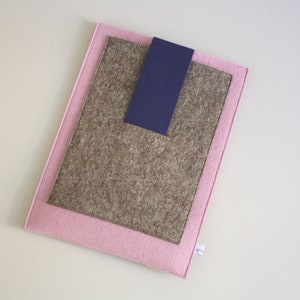 May include: A pink felt laptop sleeve with a brown felt inner layer and a navy blue felt pocket.