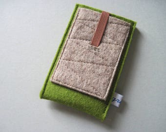 May include: A green felt phone case with a beige felt pocket and a brown felt strap. The case has a stitched design and the text "gr" is visible on the bottom right corner.