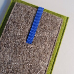 May include: A gray felt pouch with a green felt border and a blue ribbon closure.