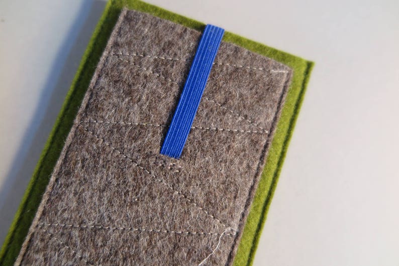 May include: A gray felt pouch with a green felt border and a blue ribbon closure.