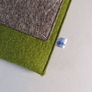 May include: A green and brown felt pouch with a white label that says "gr" in blue lettering.
