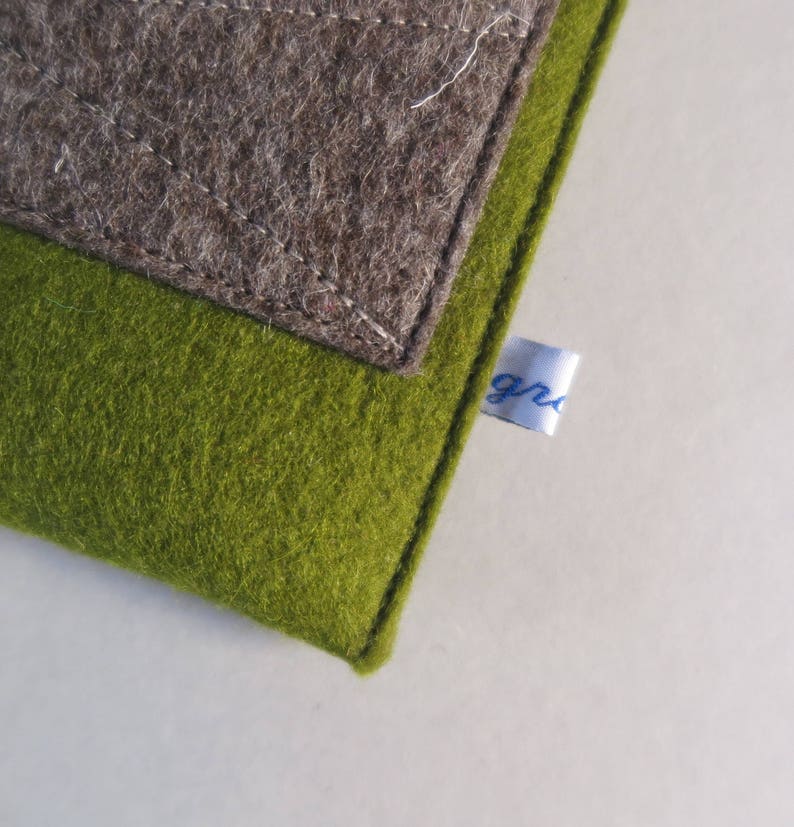 May include: A green and brown felt pouch with a white label that says "gr" in blue lettering.