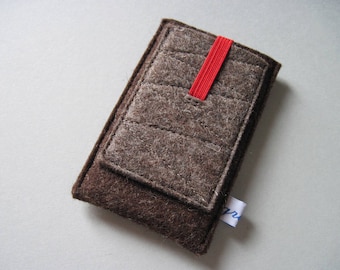 May include: A brown felt phone case with a quilted design and a red elastic band closure. The case has a small pocket on the front and a white tag with blue text.