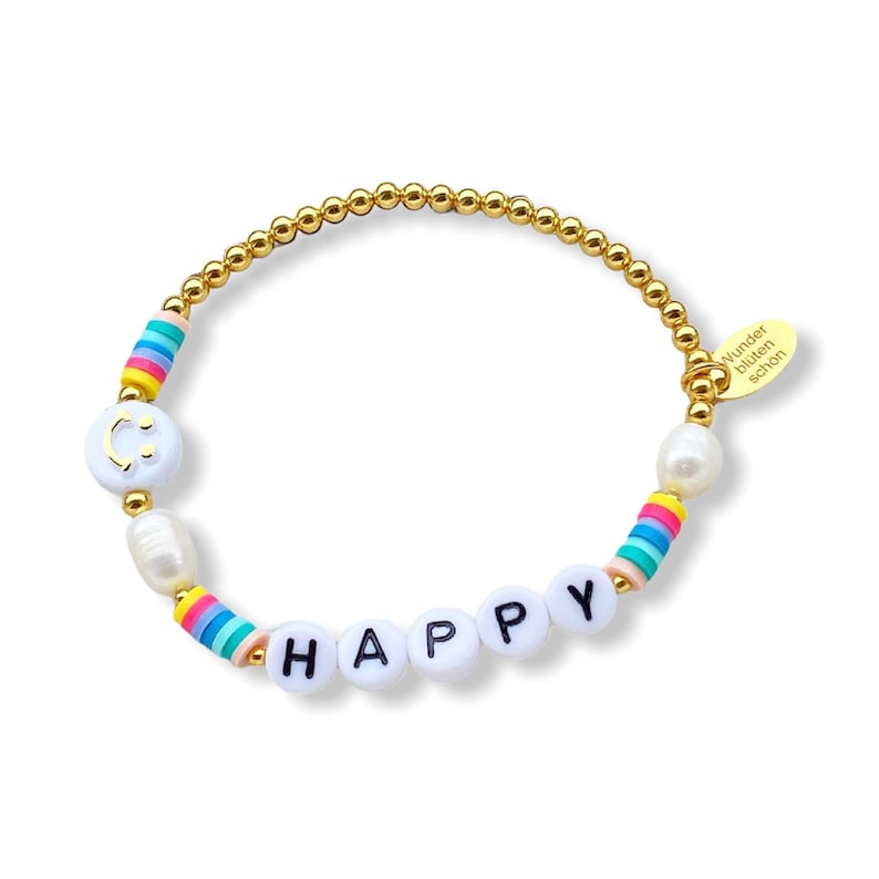 May include: Gold beaded bracelet with white beads spelling out "HAPPY" and a white bead with a smiley face. The bracelet also has a white pearl and a rainbow striped bead. The bracelet has a gold tag that says "Wunder bl&uuml;hen sch&ouml;n".