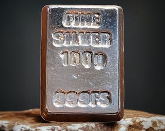 May include: A silver bar with the inscription "FINE SILVER 1000 999FS".