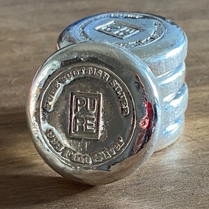 Puede incluir: Pila de cuatro barras de plata con las palabras "Pure Scottish Silver 999 Fine Silver" y "PURE" en relieve en la barra superior.