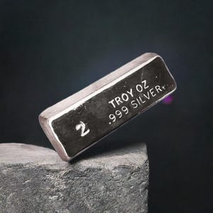 May include: A silver bar with the text "2 Troy oz .999 Silver" on it.