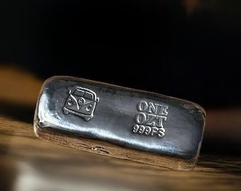 Puede incluir: Una barra de plata con un diseño de furgoneta vintage y el texto "ONE OZT 999FS" en ella.