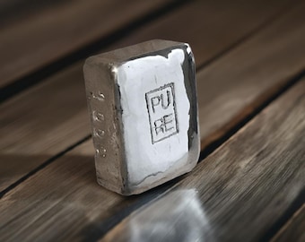 May include: A silver bar with the word "PURE" stamped on it.