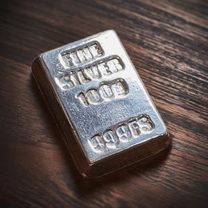 Pode incluir: Uma barra de prata com as palavras "Fine Silver 1000g 999FS" gravadas em relevo.