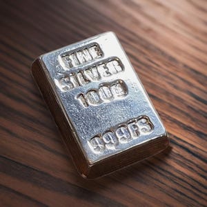 Pode incluir: Uma barra de prata com as palavras "FINE SILVER 1000g 999.9 FINE" gravadas nela.