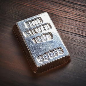 Pode incluir: Uma barra de prata com as palavras "FINE SILVER 1000g 999.9FS" gravadas nela.