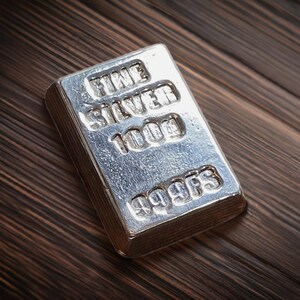 Pode incluir: Uma barra de prata com as palavras "FINE SILVER 1000" e "999FS" gravadas nela.