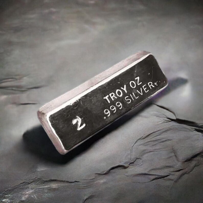 May include: A silver bar with the text "2 Troy oz .999 Silver" on it.