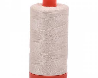 May include: A spool of beige thread with an orange plastic top and bottom.