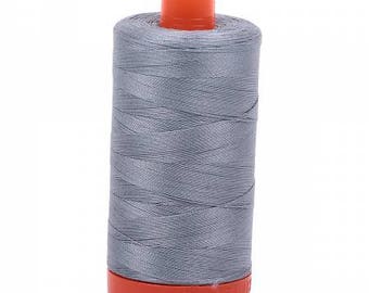 May include: A spool of gray thread with an orange plastic bobbin.