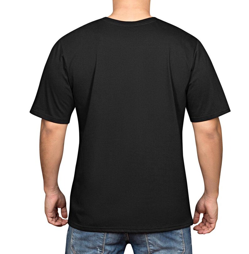 Puede incluir: Una camiseta negra lisa con cuello redondo y mangas cortas. La camiseta est&aacute; hecha de un material suave. La persona que lleva la camiseta lleva vaqueros azules.