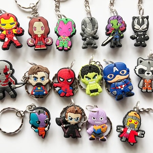 May include: A selection of superhero character keyrings in various colours. The keyrings feature characters such as Iron Man, Captain America, and Spider-Man. Each keyring has a silver metal chain and ring.