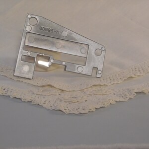 May include: A silver metal sewing machine part with the number 80993-N printed on it.