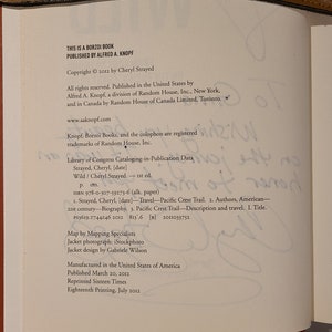 May include: A book cover with the title "Wild" by Cheryl Strayed. The book cover is brown with white text. The copyright information is printed on the bottom of the page. The book was published by Alfred A. Knopf.