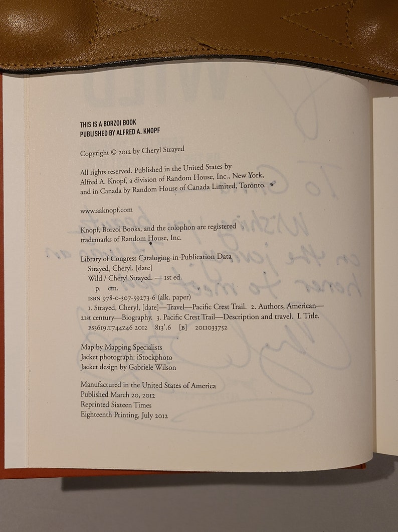 May include: A book cover with the title "Wild" by Cheryl Strayed. The book cover is brown with white text. The copyright information is printed on the bottom of the page. The book was published by Alfred A. Knopf.