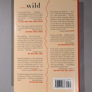 May include: Book cover for "Wild" by Cheryl Strayed. The cover features a red, white, and blue color scheme with a stylized image of a mountain range. The title "Wild" is in large, white letters. The book is a memoir about Strayed's journey on the Pacific Crest Trail.