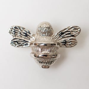 6 pomos de cajón con diseño de abeja plateada, acabado cromado y herrajes de latón.