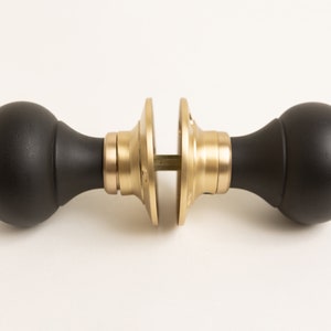 May include: Black and gold door knob with round handles.