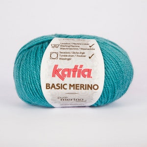 May include: A ball of teal blue Katia Basic Merino superwash pure merino wool yarn. The label says "120 mts. - 131 yds." and includes washing and drying instructions.