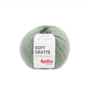 May include: A ball of soft green yarn labelled "Soft Gratte" with the brand name "Katia" and the text "Non-Stop Creativity" and "100% You".