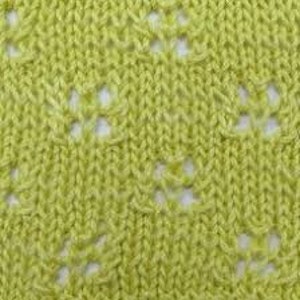 May include: A close-up of a light green knitted fabric with a repeating diamond pattern. The fabric has a delicate openwork design, creating a lacy effect.