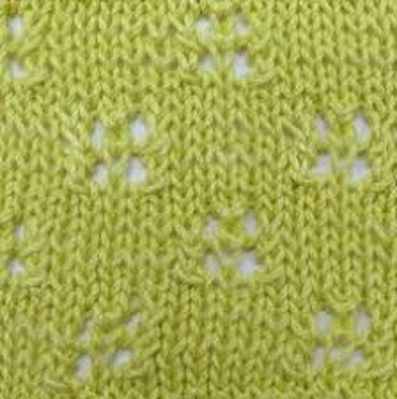 May include: A close-up of a light green knitted fabric with a repeating diamond pattern. The fabric has a delicate openwork design, creating a lacy effect.