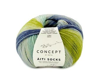 Könnte beinhalten: Ein Knäuel aus mehrfarbigem Garn in Limettengrün, Mint und Marineblau. Das weiße Papieretikett trägt die Aufschrift Concept by Katia Äiti Socks, Soft Merino Wool & Lyocell, All Seasons Socks & More, 100g, 400m, 75% Merino, 25% Polyamide.