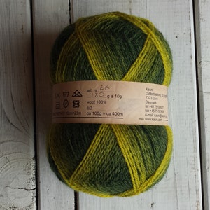 May include: A skein of green and yellow yarn with a label that reads "art. nr. EK LBC g 10g wool 100% 8/2 ca 100g ca 400m Kaun Oddernesvej 13 7323 Give Denmark tel +45 75190227 fax +45 75190228 e-mail kaun@kaun.dk www.kaun.dk"