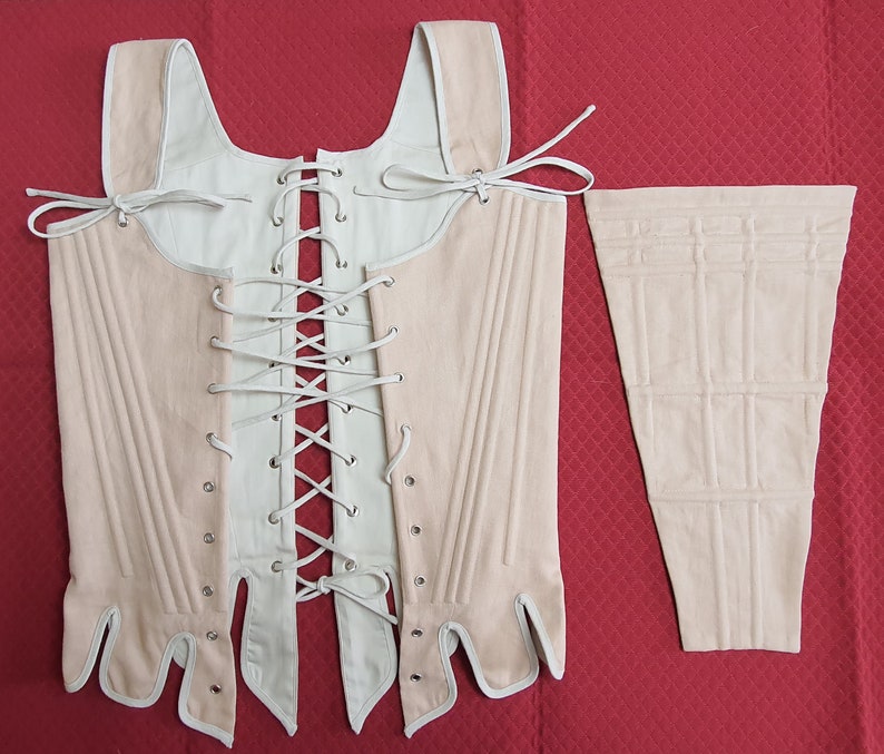 Puede incluir: Un cors&eacute; crema y rubor con un panel separado a juego. El cors&eacute; presenta un frente con cordones, tirantes y un dise&ntilde;o estructurado. El panel tiene una serie de l&iacute;neas cosidas verticales y horizontales.