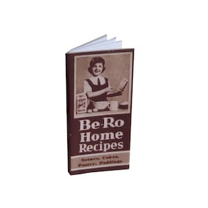 May include: A brown cookbook titled "Be-Ro Home Recipes" featuring a photograph of a woman baking. The cookbook contains recipes for scones, cakes, pantry items, and puddings.