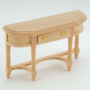 Peut inclure: Une console en bois avec un tiroir et des pieds tournés. La table a un dessus incurvé et un design simple.