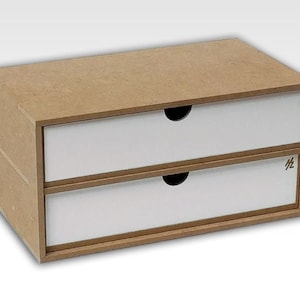 Puede incluir: Un organizador de dos cajones hecho de madera marrón con frentes de cajones blancos. El organizador tiene un diseño simple y es perfecto para guardar objetos pequeños.