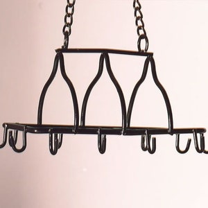 May include: Black metal pot rack with multiple hooks hanging from a chain.