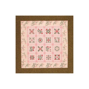 May include: A pink and green patchwork quilt with a floral design. The quilt is made up of 12 squares, each with a different pattern. The quilt is surrounded by a brown border.