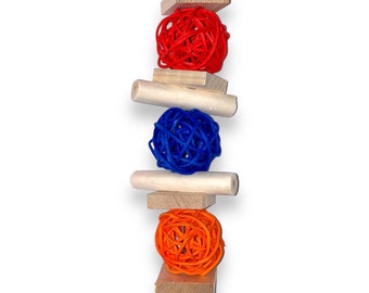 May include: A wooden bird toy with three colorful woven balls. The balls are red, blue, and orange. The toy is attached to a metal hook.