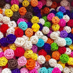 May include: A close-up of a variety of colorful, round, woven balls. The balls are made of natural materials and have a variety of textures. They are arranged in a random pattern and create a visually appealing display.