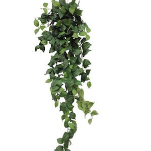 May include: A hanging artificial plant featuring numerous cascading stems covered in small, pointed, dark and light green leaves. The foliage is arranged in a dense, trailing cluster that extends downwards, creating a full and textured appearance.
